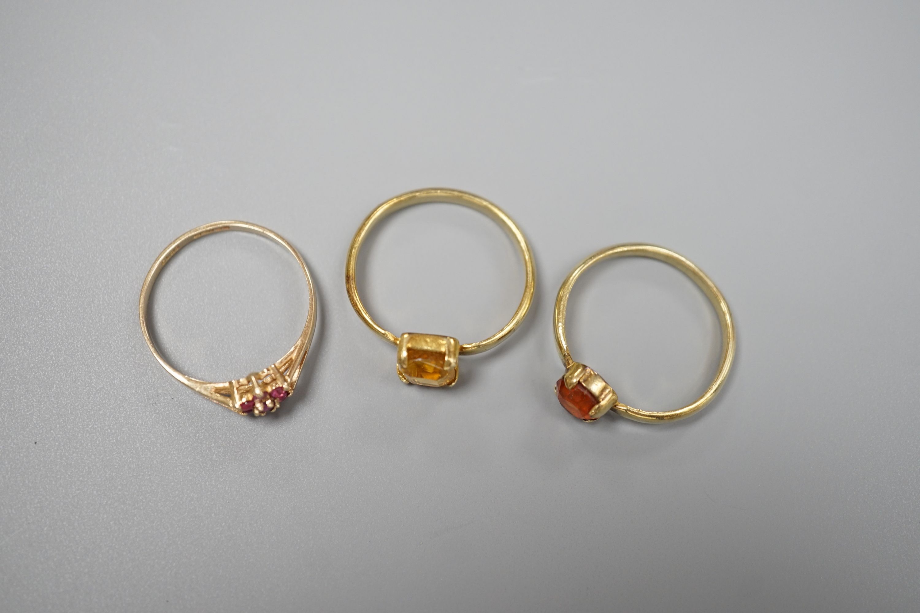 Two yellow metal and gem set rings, including garnet and citrine and a 9ct gold and gem set cluster ring, gross 5.5 grams.